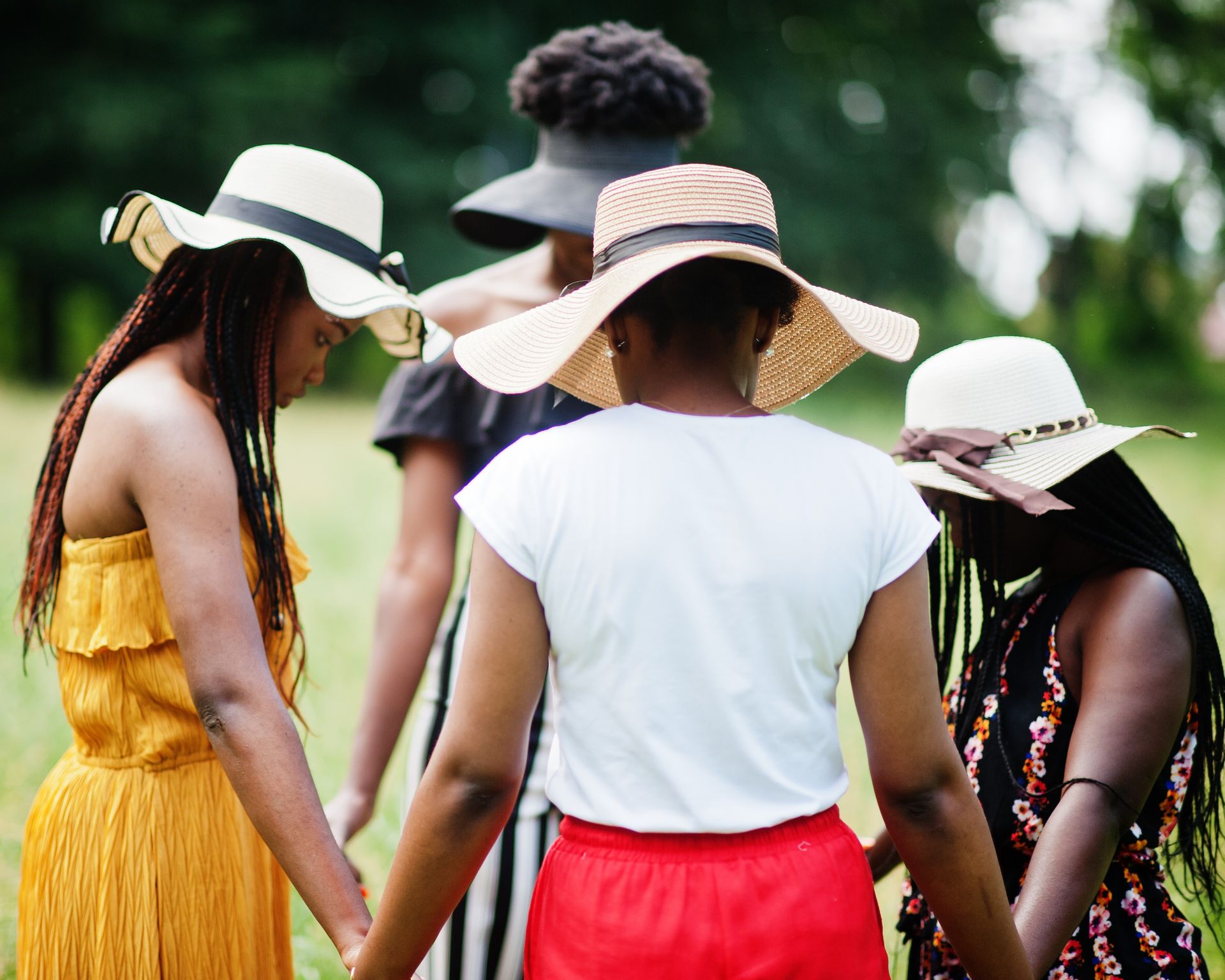 group-four-gorgeous-african-american-womans-wear-summer-hat-holding-hands-praying-green-grass-park